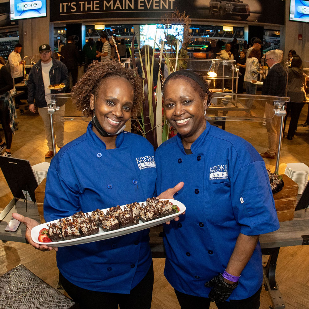 two women holding a platter