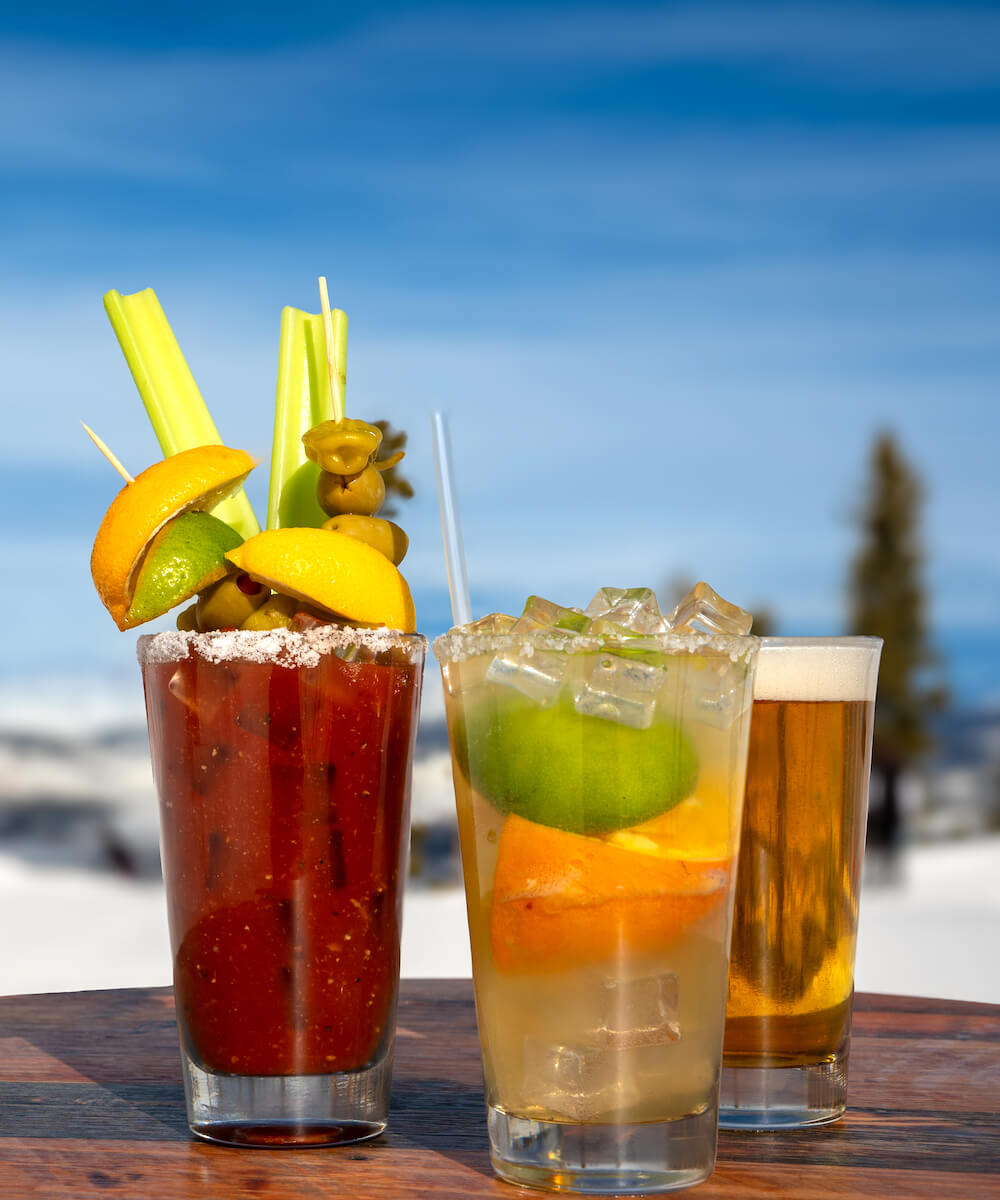 drinks on a table in front of a mountain